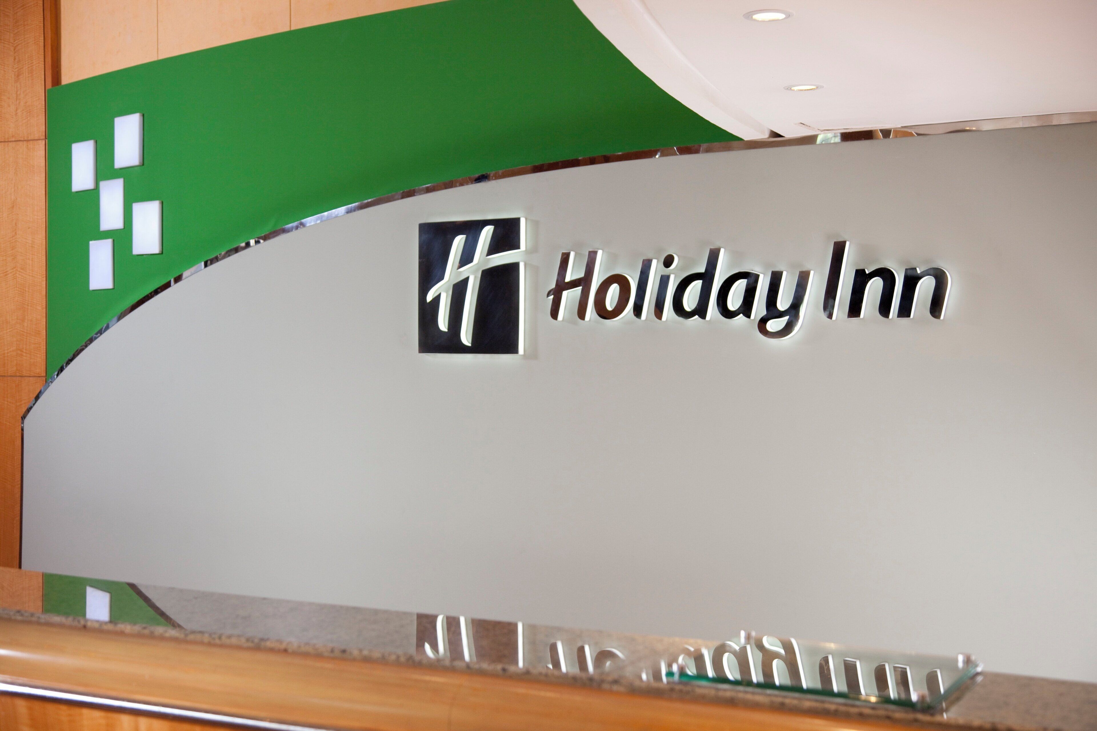 A sign for Holiday Inn with a logo and name.