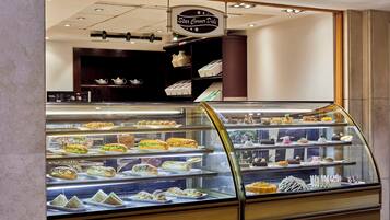 A deli counter with a variety of sandwiches and pastries displayed in a glass case.
