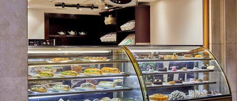 A deli counter with a variety of sandwiches and pastries displayed in a glass case.
