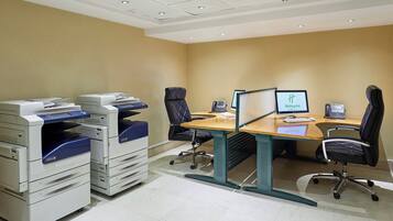 A conference room with a desk, chairs, a computer, and Xerox printers.