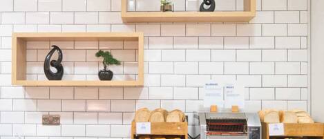 A bakery display with bread and pastries, a coffee machine, and a sign about allergies and intolerances.
