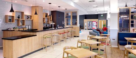 A modern cafe with wooden furniture, a bar area, and a seating area with colorful chairs.