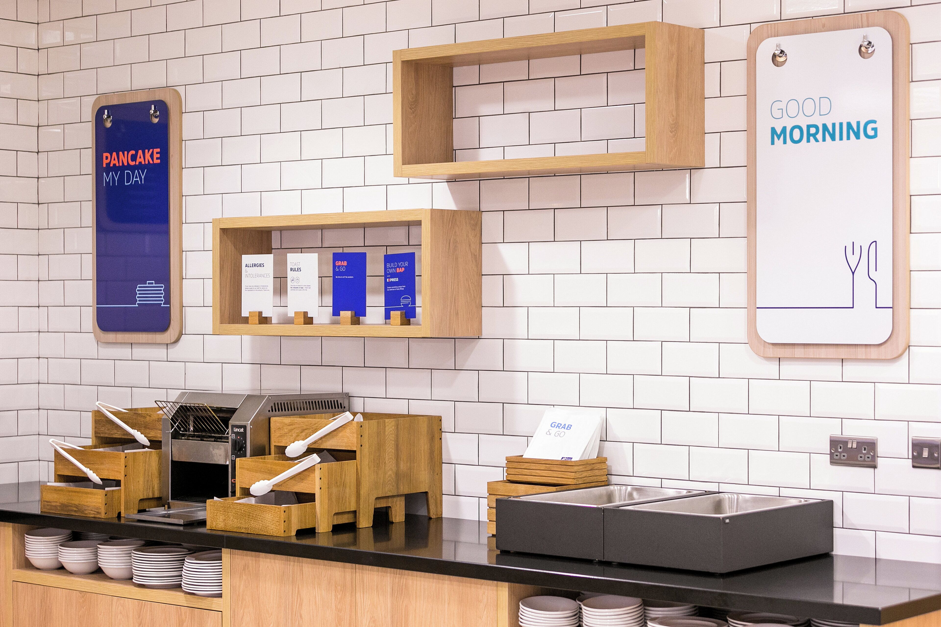 A breakfast area with a counter, a waffle maker, and a sign that reads 'GOOD MORNING'.