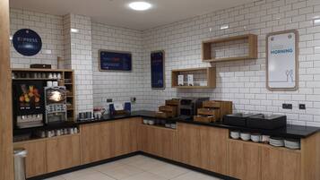 A modern kitchen area with a coffee station, a wake-up sign, and a breakfast sign.
