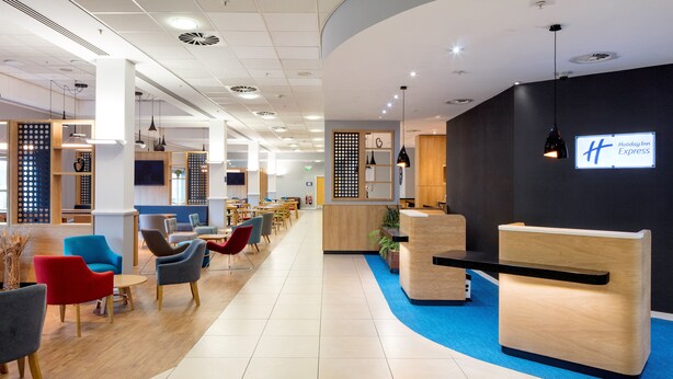 A modern hotel lobby with a reception desk, seating area, and a Holiday Inn Express sign. - Holiday Inn Express Hull City Centre by IHG (Hull)