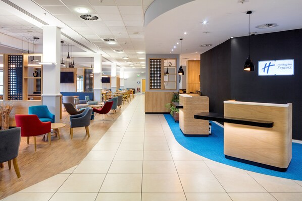 A modern hotel lobby with a reception desk, seating area, and a Holiday Inn Express sign. - Holiday Inn Express Hull City Centre by IHG (Hull)