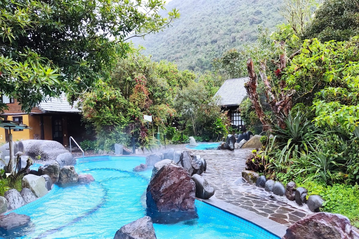 A pool with natural rock formations and a stone pathway.