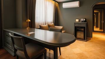 A modern hotel room with a dining table, a sofa, a desk, and a cabinet.