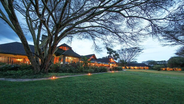 A large, well-lit building with multiple sections, surrounded by a grassy area and trees. - Muthu Keekorok Lodge, Maasai Mara, Narok (Maasai Mara)