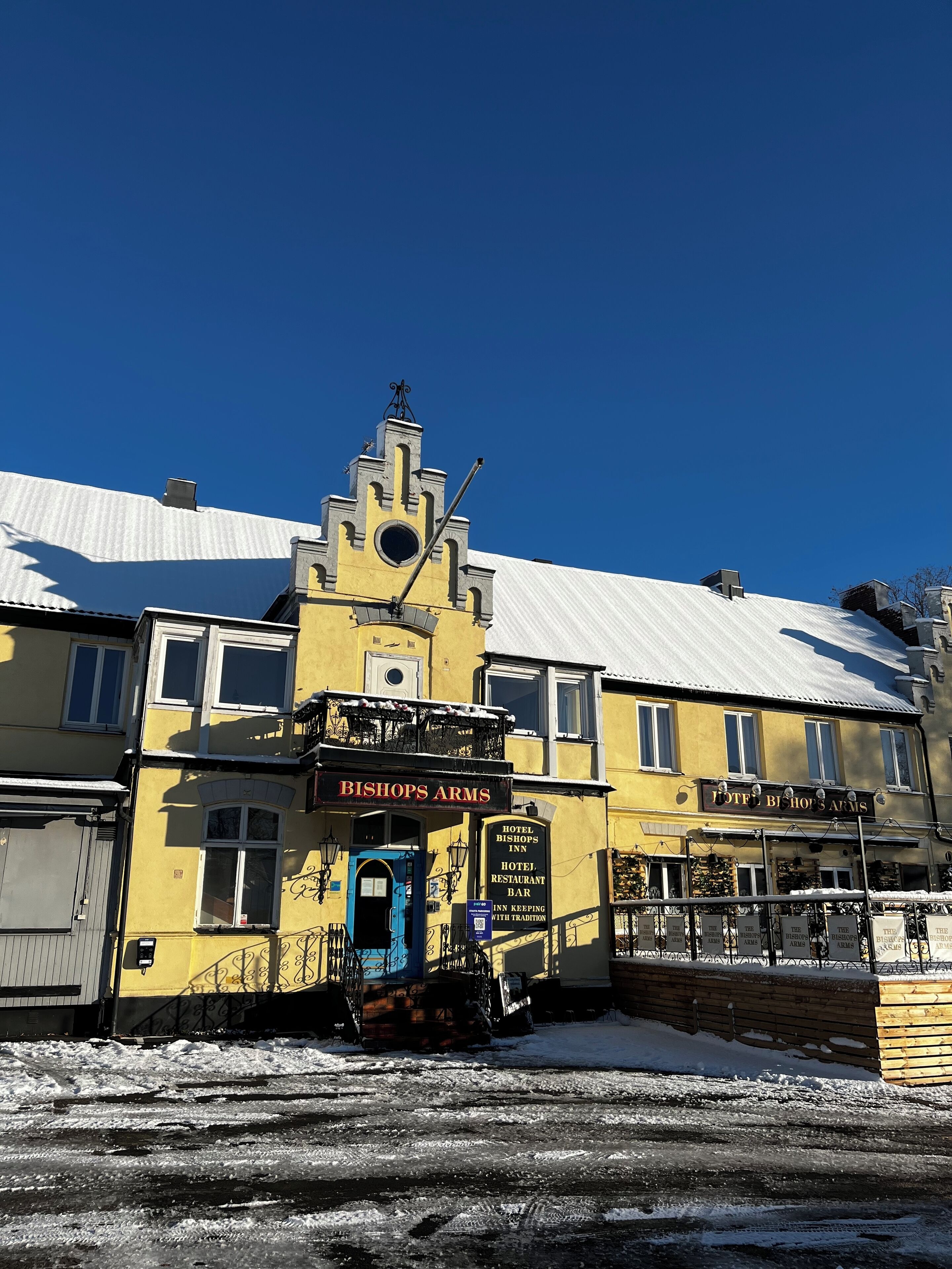 A yellow building with a sign reading "BISHOP'S ARMS HOTEL RESTAURANT BAR".