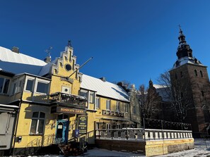 A historic building with a clock tower, a prominent yellow facade, and a sign for 'Bishop's Arms Hotel, Restaurant, and Bar'. - Hotel Bishops Arms Kristianstad (Kristianstad)