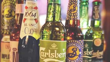 A variety of beer bottles on a wooden surface.