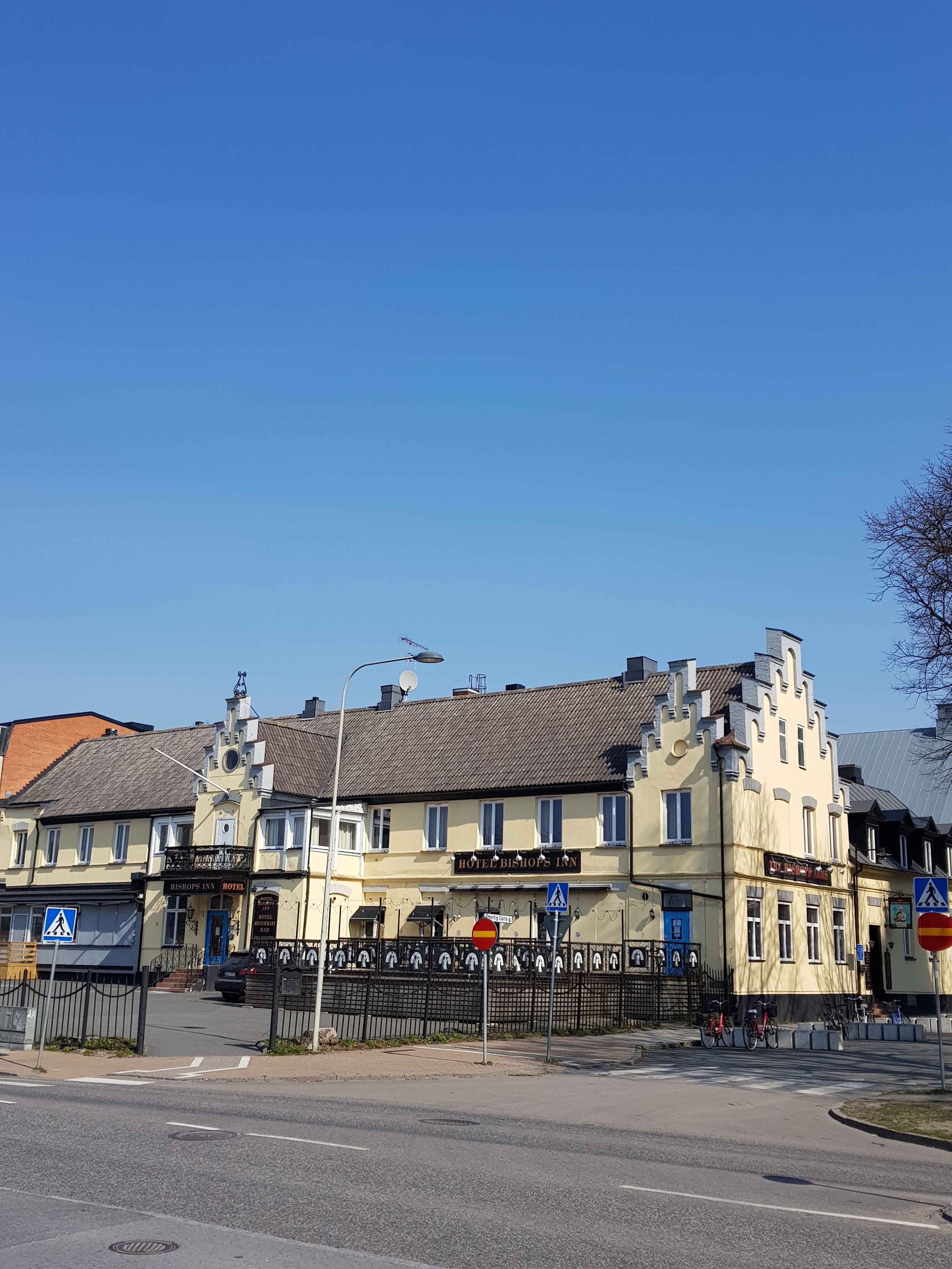 A historic building with a sign for 'Hotel Bishops Inn' and a pedestrian crossing.