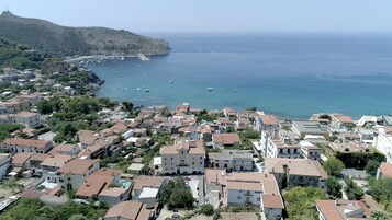 Un pueblo costero con una mezcla de edificios residenciales y un paisaje montañoso de fondo.