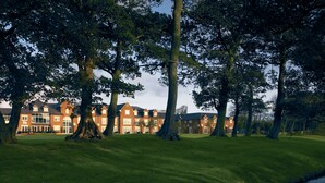 A large brick building with multiple windows and a lawn in front. - Formby Hall Golf Resort & Spa (Liverpool)