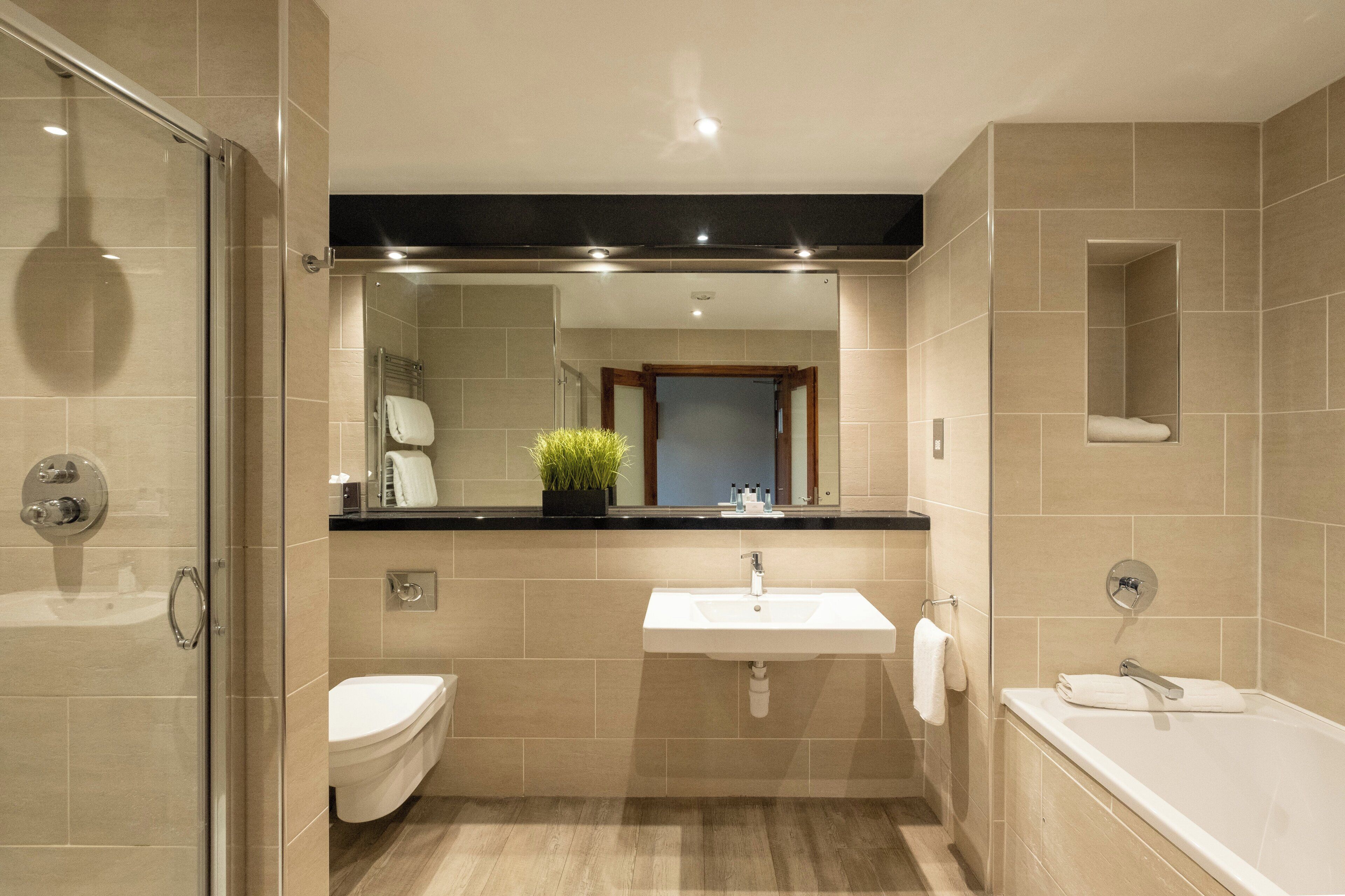 Un baño moderno con cabina de ducha de vidrio, un lavabo y una bañera.