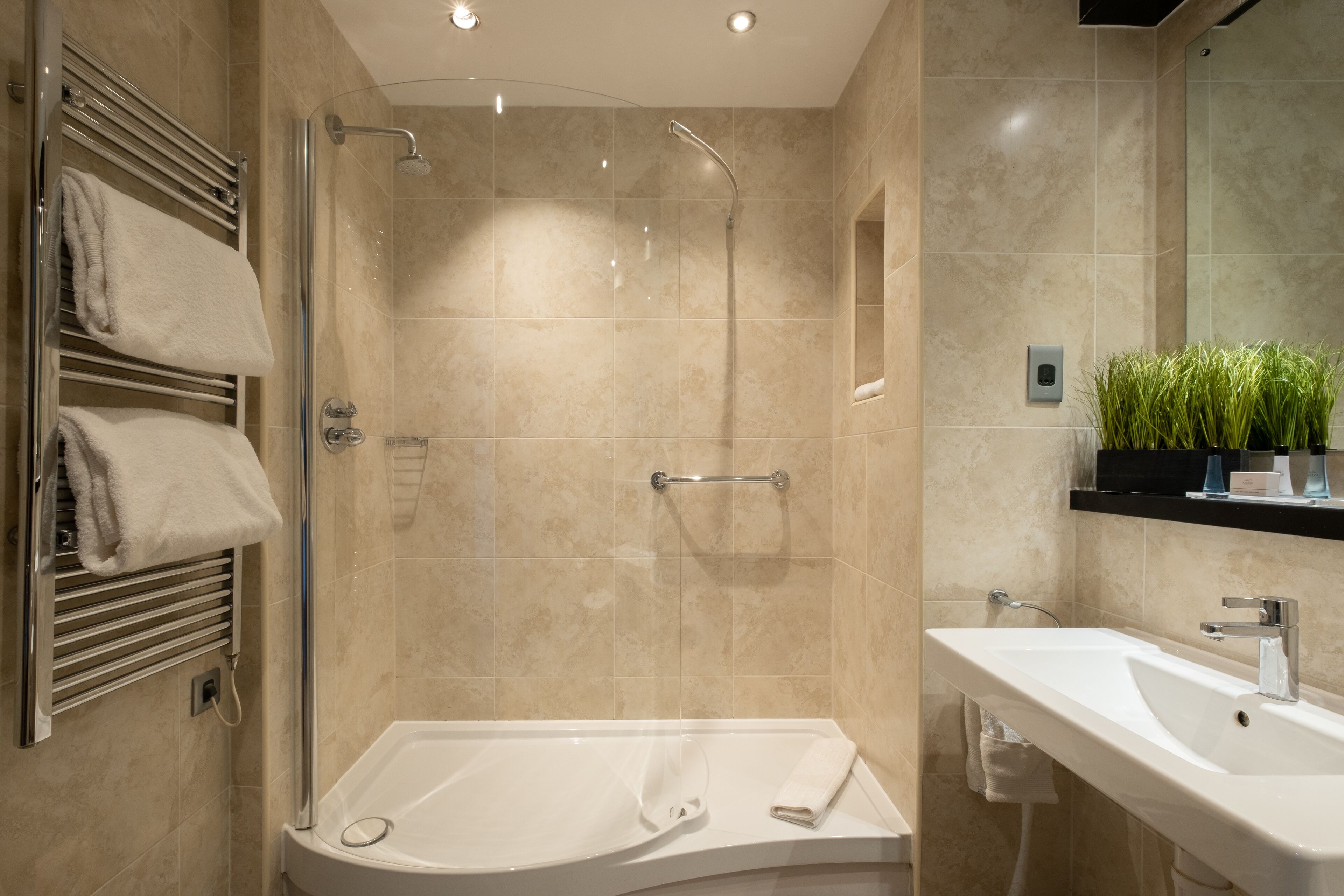 A modern bathroom with a walk-in shower, a bathtub, and a sink.