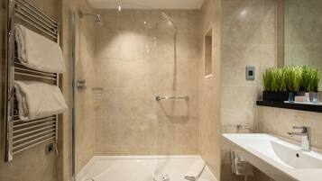 A modern bathroom with a walk-in shower, a bathtub, and a sink.