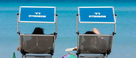 Playa en los alrededores, playa de arena blanca, camastros y sombrillas