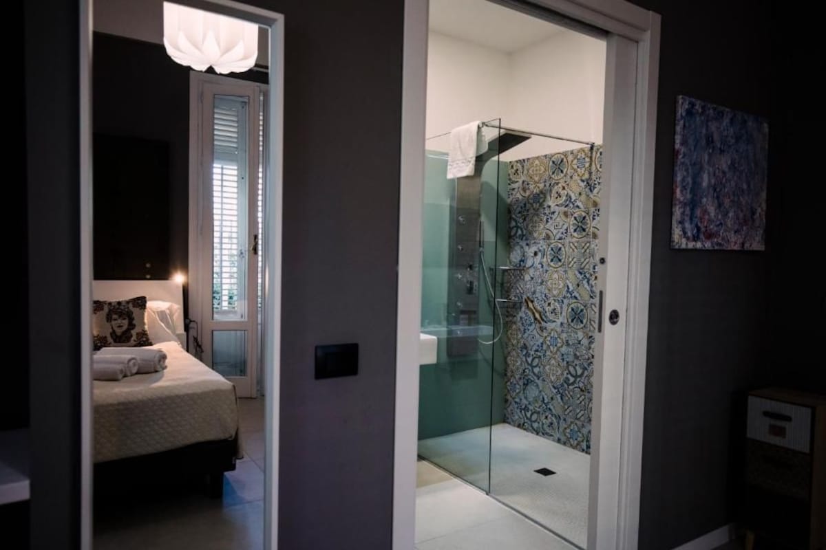 A bedroom with a bed, a bedside table, and a nightstand.