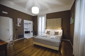Un dormitorio con una cama grande, un escritorio y una silla.