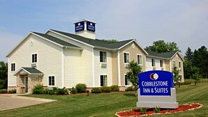 Ett hotell i två våningar med en skylt som visar texten ”Cobblestone Inn & Suites”.