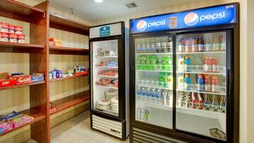 Ein Hotelzimmer mit Minibar, gefüllt mit Snacks, Getränken und Pflegeartikeln.