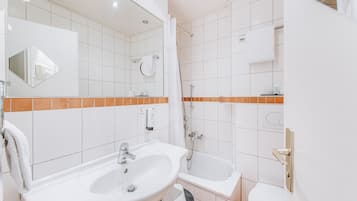Un baño moderno con lavamanos, bañera y ducha.