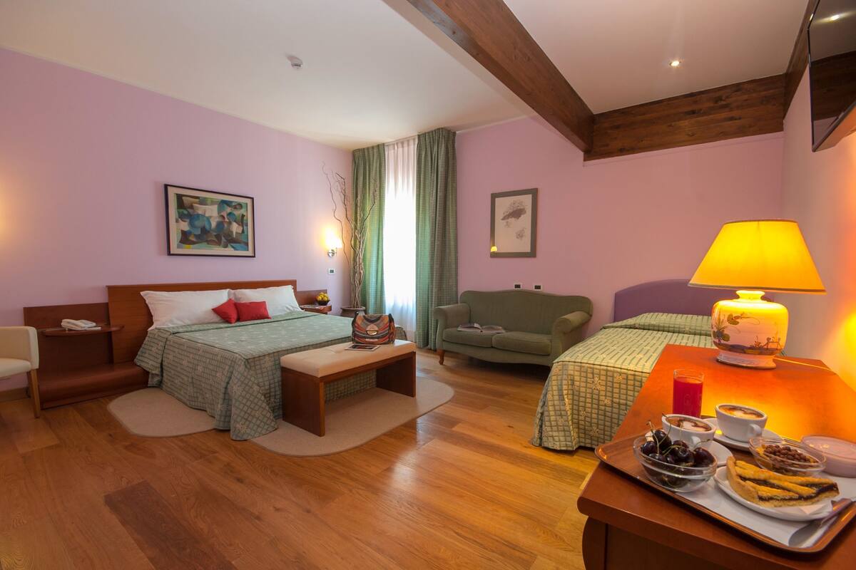 Un dormitorio con cama, mesita de noche, lámpara y bandeja para el desayuno.
