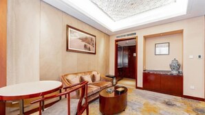 A hotel lobby with a high ceiling, a round table, a sofa, and a coffee table.