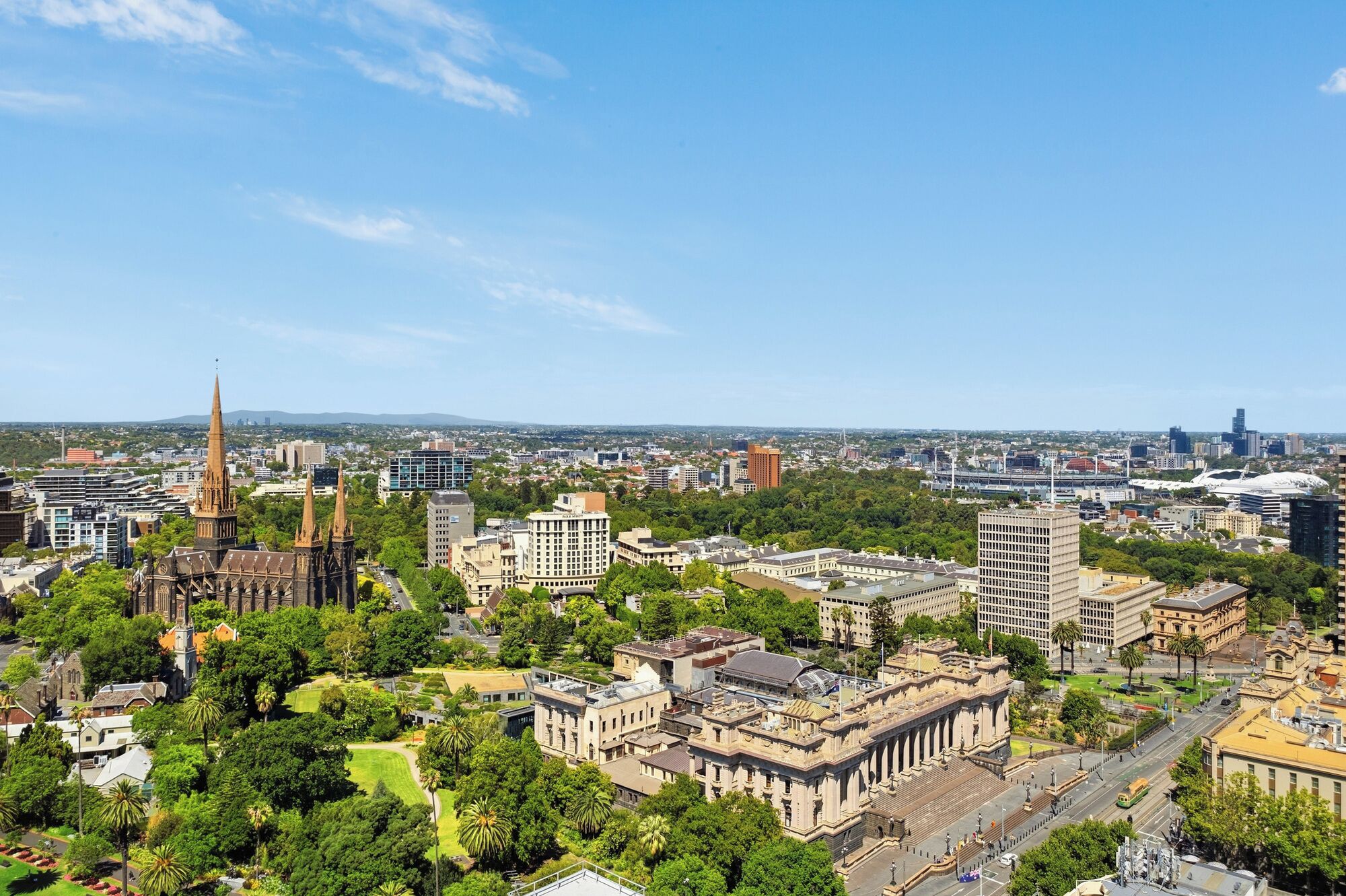 A cityscape with a prominent cathedral, modern buildings, and green spaces.