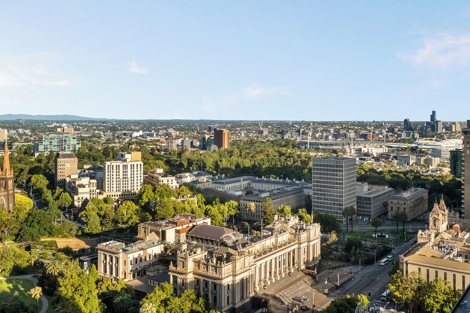 Un paysage urbain mêlant bâtiments modernes et bâtiments historiques, une église imposante et une vaste place publique.
