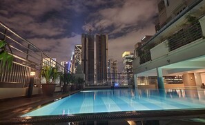 Una piscina en la azotea con un horizonte urbano de fondo.