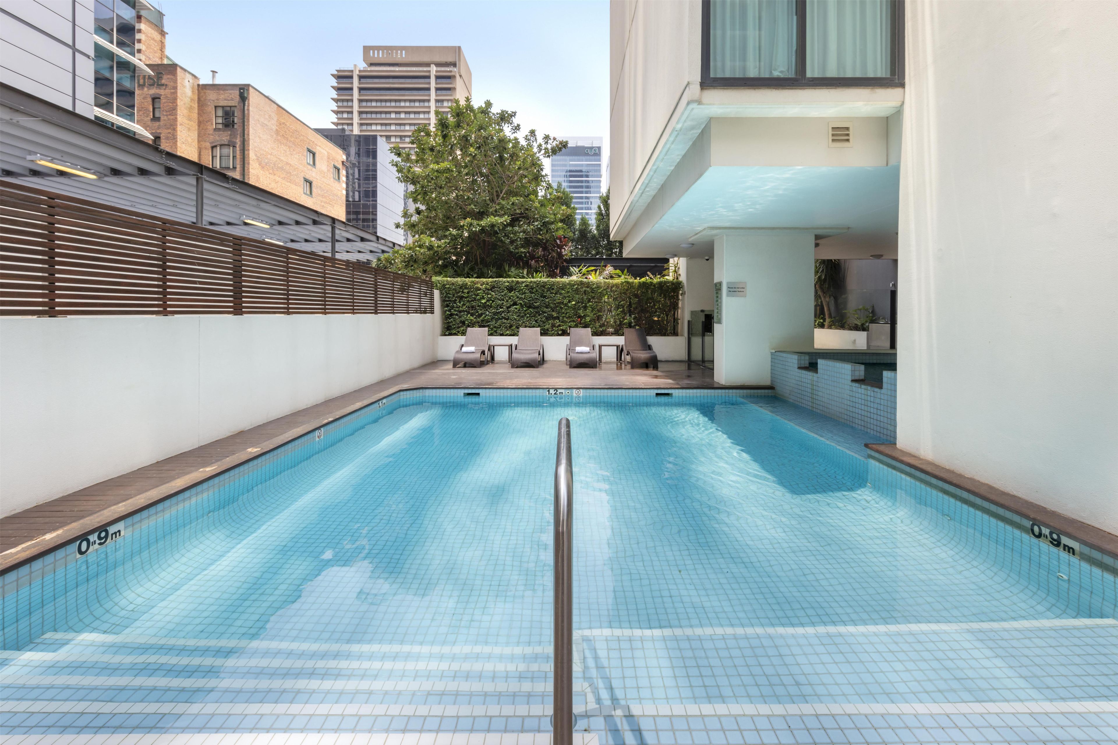 Piscina com vista para edifícios altos ao fundo.