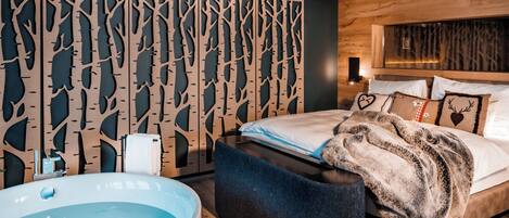 Un dormitorio moderno con una cama grande, cabecera de madera, panel decorativo en la pared y una bañera.