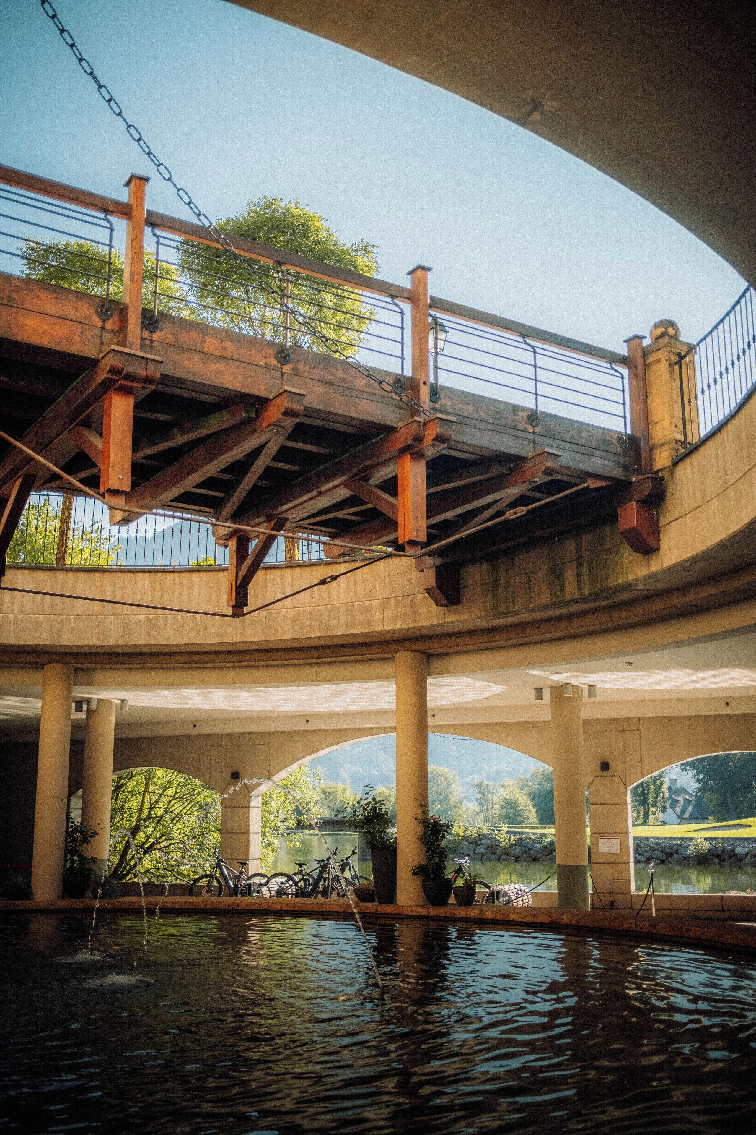 A bridge with a chain-link railing, wooden beams, and a concrete structure.