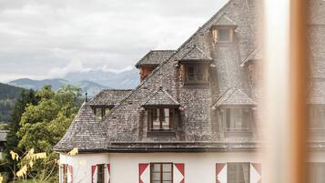 Una cabaña tradicional con techo inclinado, varias ventanas y vistas del paisaje circundante.