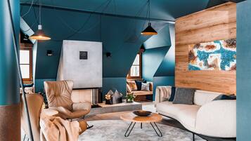 Una sala de estar moderna con un sofá, sillones, una mesa de centro e iluminación colgante.