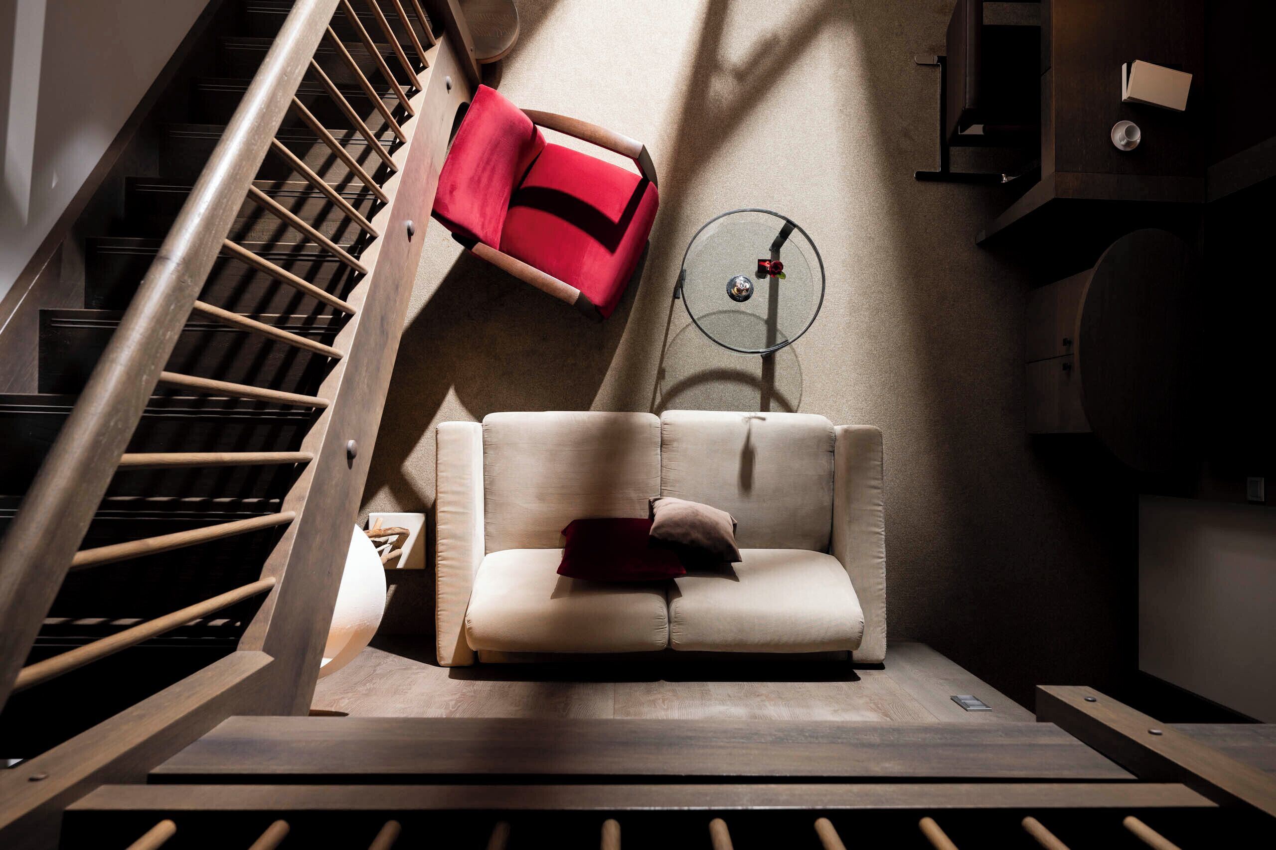 A modern interior with a staircase, a sofa, and a small round table.