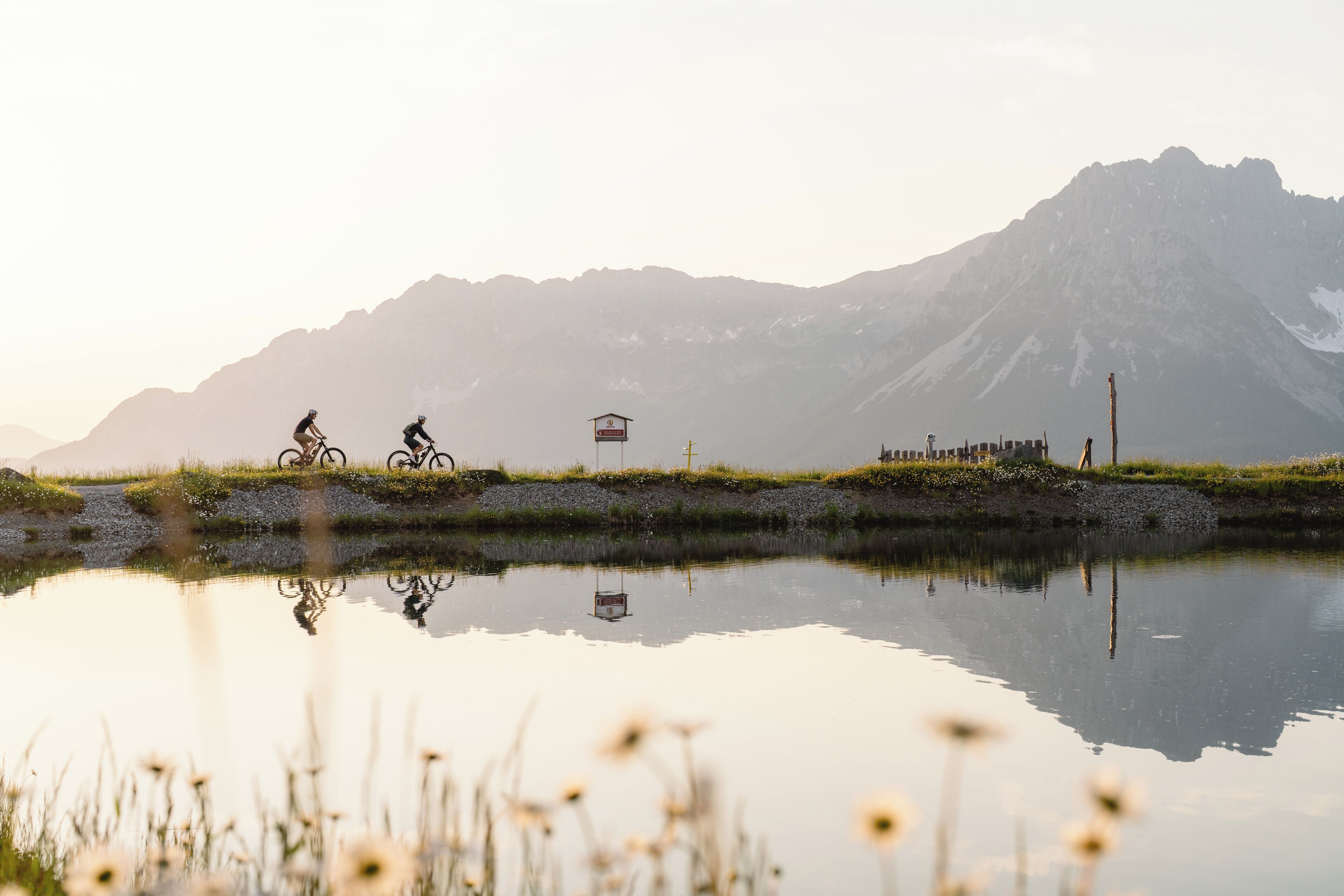 Eine Berglandschaft mit einem stillen See, der die Umgebung spiegelt.