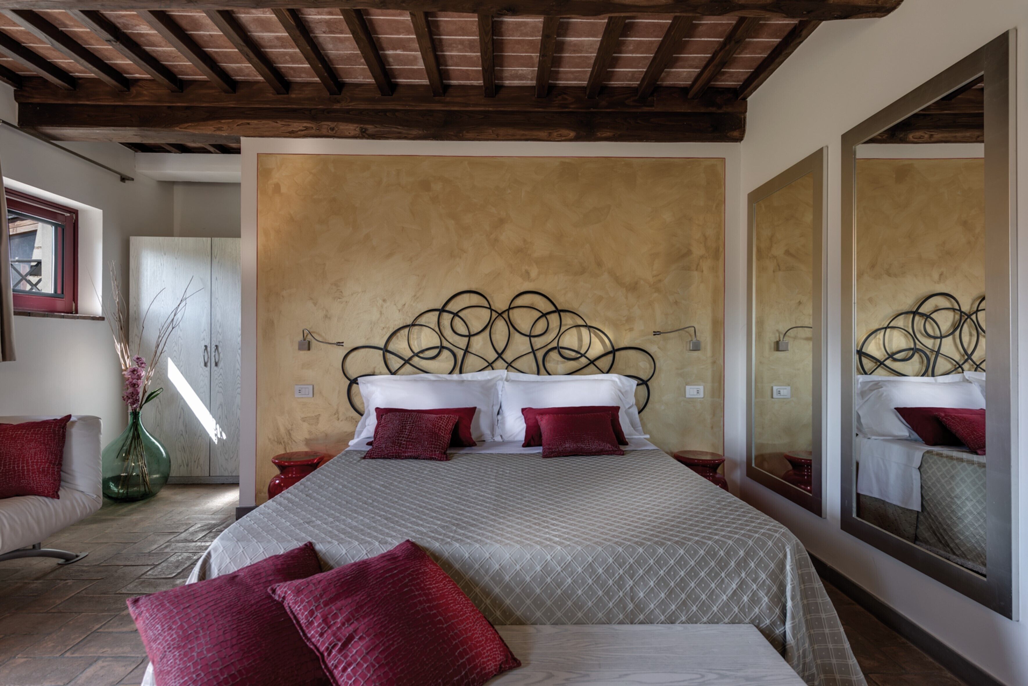 Un dormitorio con una cama grande, techo de madera y un espejo en la pared.