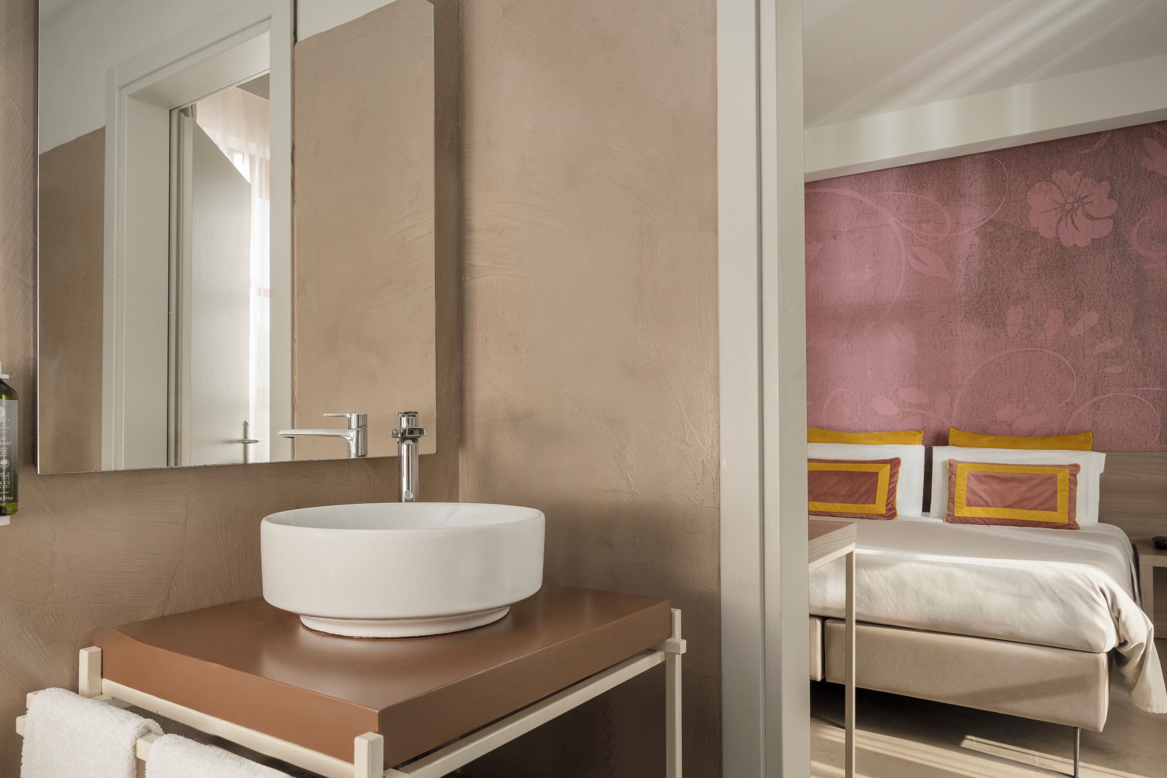 A bathroom with a white sink, a mirror, and a towel rack.