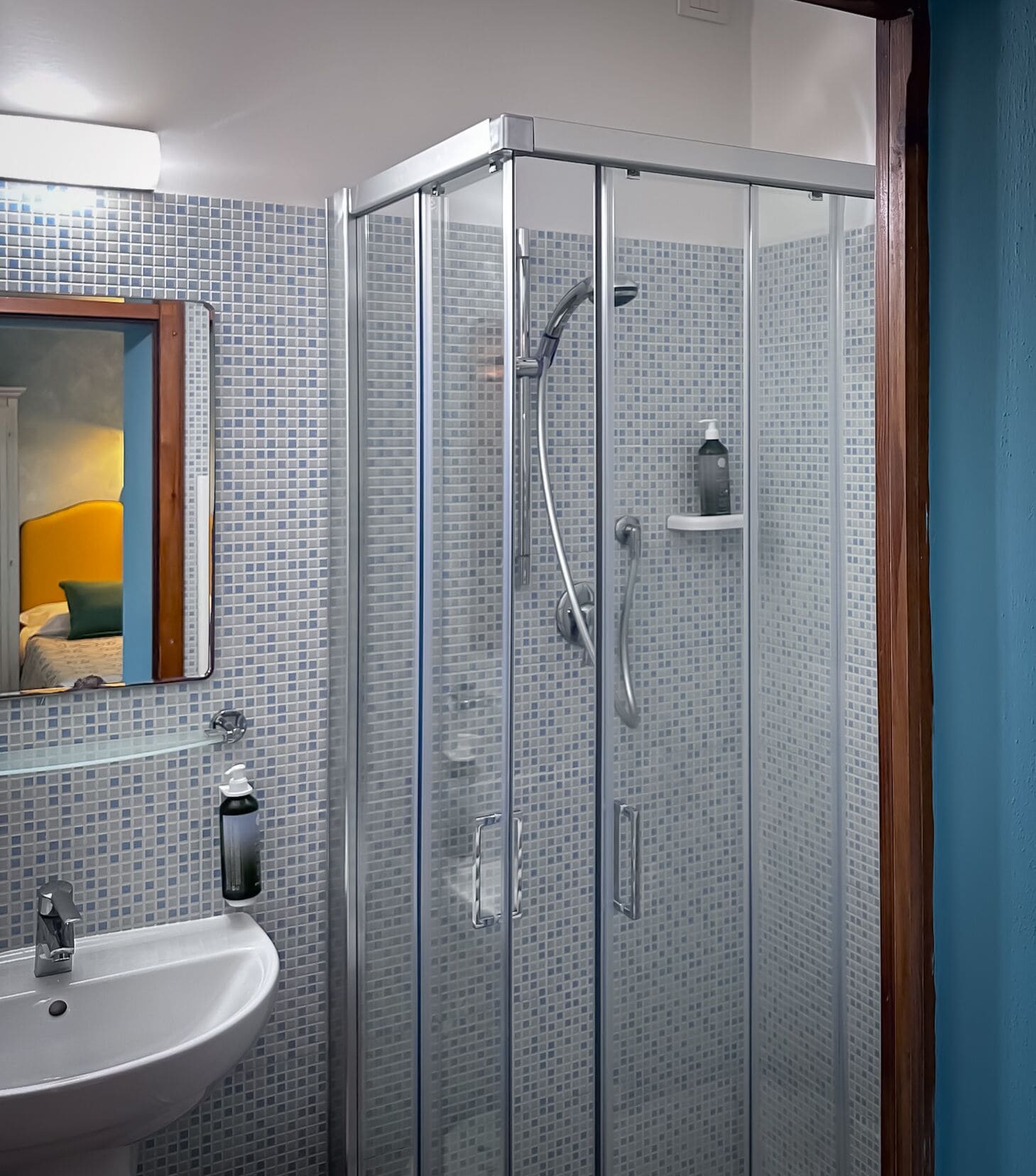 A modern bathroom with a glass-enclosed shower, a sink, and a mirror.