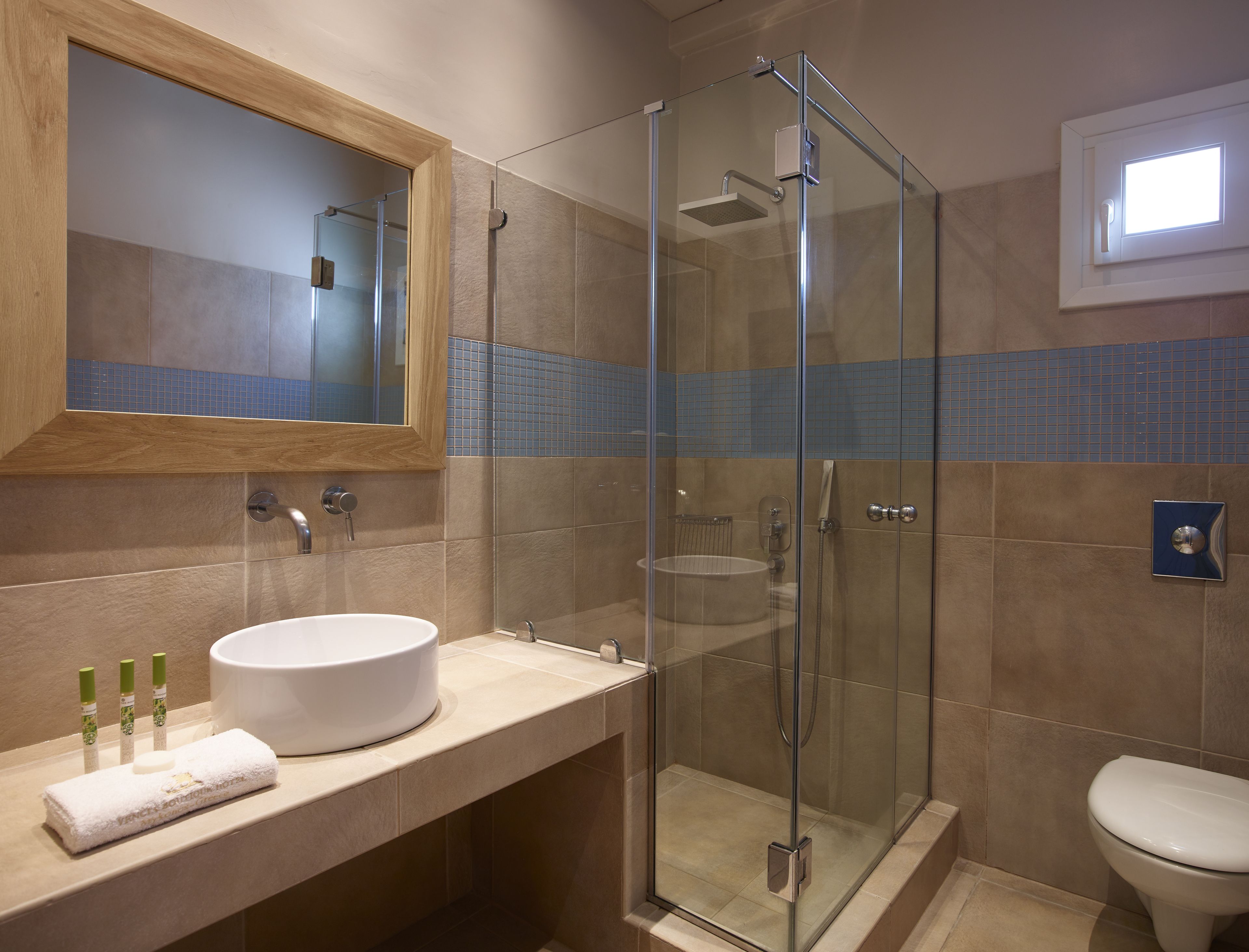 A modern bathroom with a glass-enclosed shower, a large sink, and a toilet.
