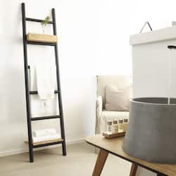 Simple, modern space with a black ladder, white chair, and a small potted plant.