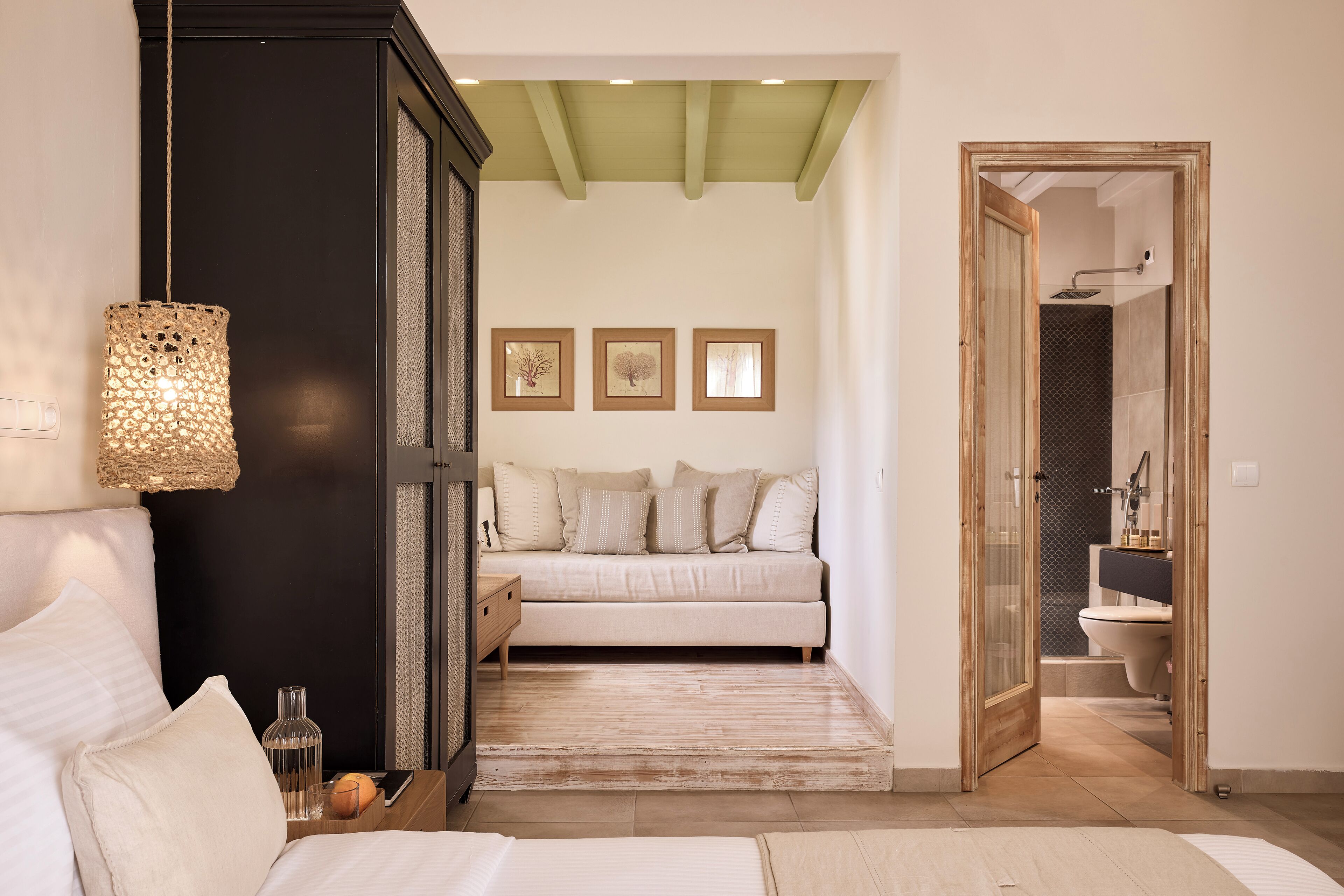 Un dormitorio con cama, mesita de noche y lámpara colgante.