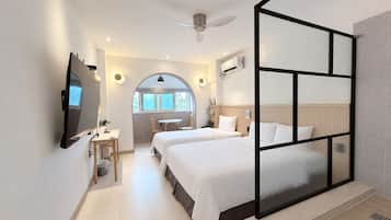 Una habitación de hotel moderna con una cama grande, un escritorio y vistas al exterior.