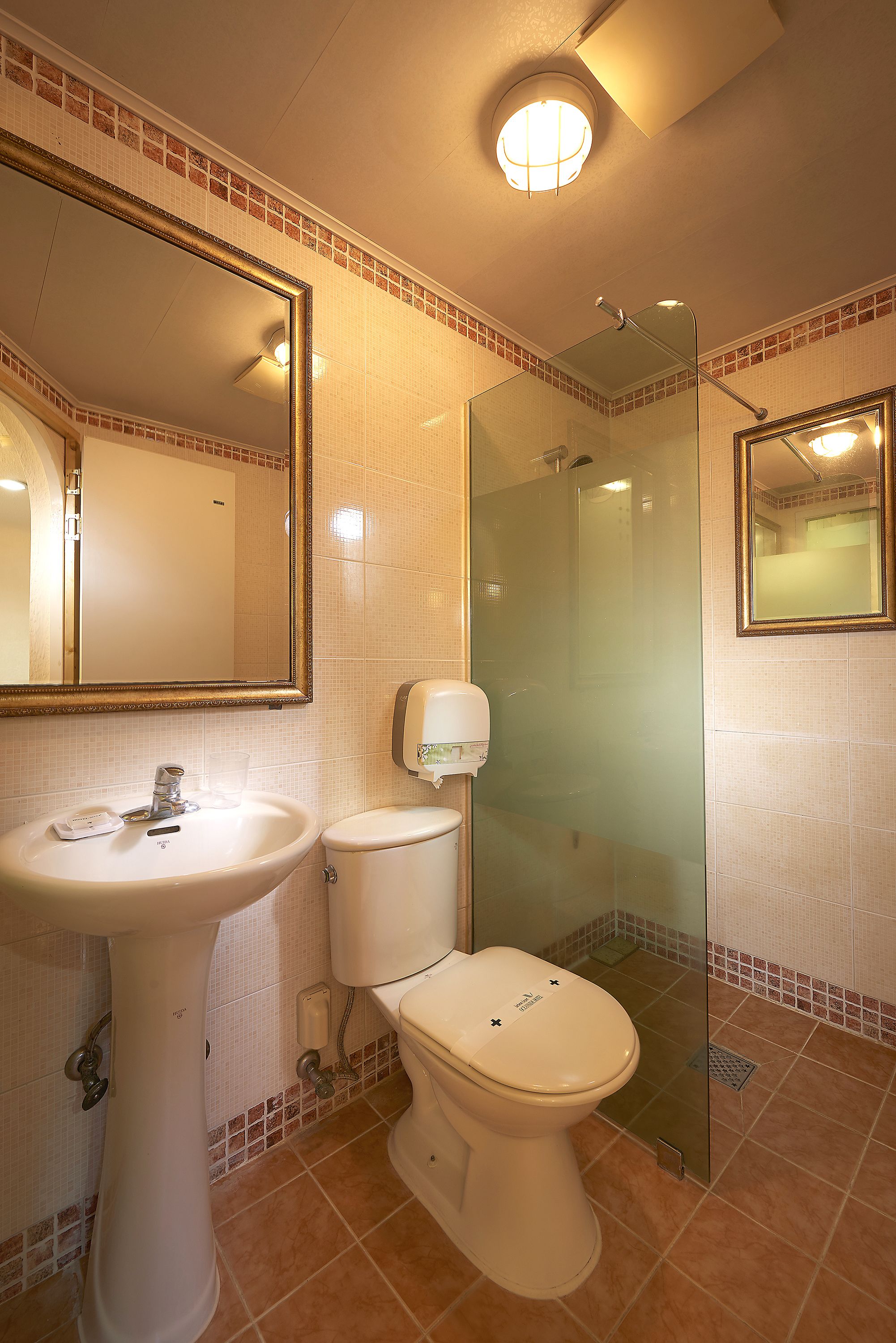 A bathroom with a sink, toilet, and glass-enclosed shower.