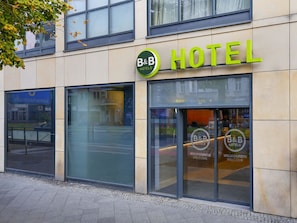 Un hotel tipo B&B con fachada moderna, grandes ventanales y una entrada acogedora.