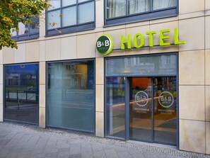 Un hotel d'estades amb façana moderna, grans finestres de vidre i una entrada acollidora.